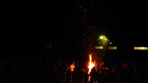 Campers and staff gathered around bonfire.