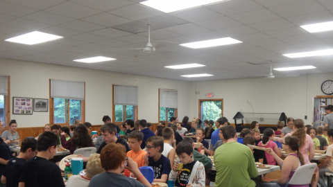Campers and counselors seated together for a family style meal.